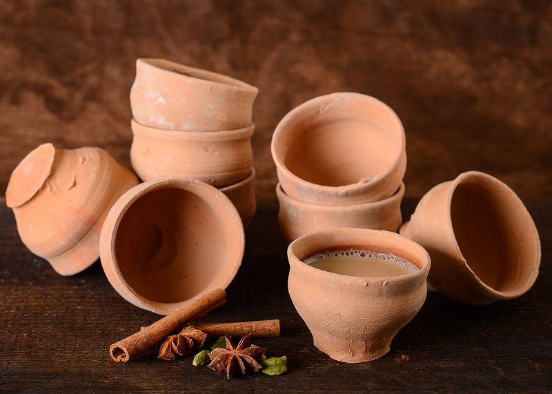 collection of clay chai cups and dry spices