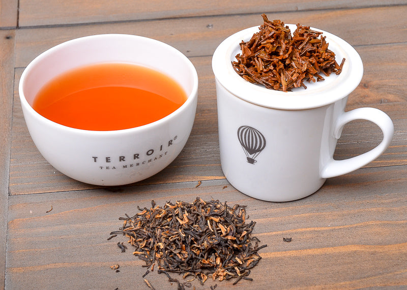 cupping set with wet leaves and brewed tea