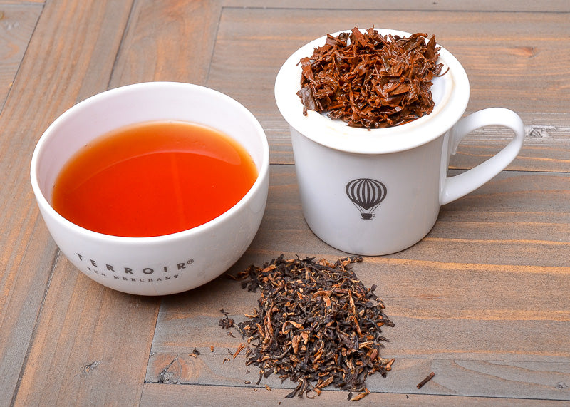 cupping set with wet leaves and brewed tea